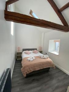 a bedroom with a bed with two towels on it at Spacious 4 bedroom, 4 bathroom barn conversion home with private garden and free parking in Burn