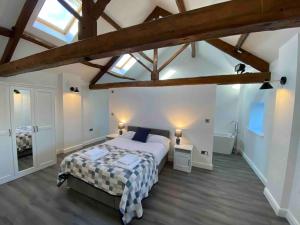 a bedroom with a large bed in a attic at Spacious 4 bedroom, 4 bathroom barn conversion home with private garden and free parking in Burn