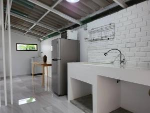 a kitchen with a sink and a refrigerator at Minimal homey near Ruam Chok mall 15 min to city. in Chiang Mai
