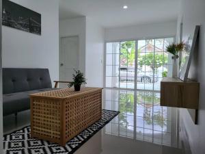 a living room with a wicker table and a couch at Minimal homey near Ruam Chok mall 15 min to city. in Chiang Mai