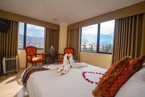 una habitación de hotel con una cama con una decoración de corazón. en Hotel Agustos Cusco, en Cusco