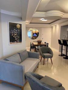 a living room with a couch and a table at Brisa Mar Apartamento Aconchego in Balneário Camboriú