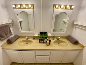 a bathroom with two sinks and two mirrors at Rancho Dominique Valle de Guadalupe in Valle de Guadalupe +29 photos