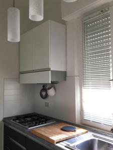 een keuken met witte kasten, een fornuis en een wastafel bij Villa al mare in Senigallia