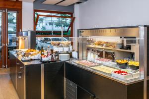 uma cozinha com uma linha de buffet com comida em exposição em Hotel La Pergola Dependance em Lignano Sabbiadoro