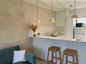 a kitchen with a counter and two stools in a room at Mineral Stone- T2 Standing in Cayenne
