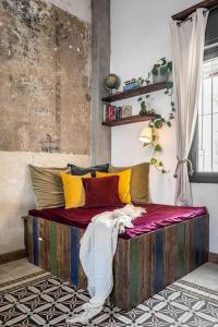 a bed with colorful pillows on it in a room at Luxury&Design apartments in Florentine in Tel Aviv