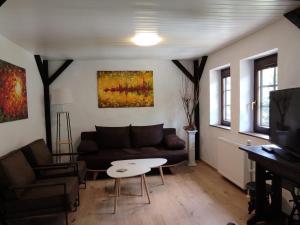salon z kanapą i stołem w obiekcie Ferienwohnung 'Unter der Burg' w mieście Brodenbach