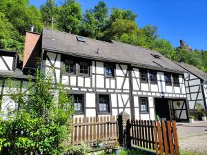 a white and black house with a wooden fence at Ferienwohnung 'Unter der Burg' in Brodenbach