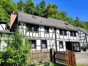 une maison blanche et noire avec une clôture en bois dans l'établissement Ferienwohnung 'Unter der Burg', à Brodenbach