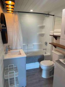 a bathroom with a sink and a toilet and a tub at Sunrise Loft - Beach front guest house in Sandspit