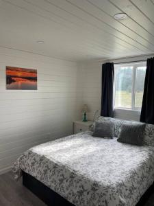 um quarto com uma cama e uma janela em Sunrise Loft - Beach front guest house em Sandspit