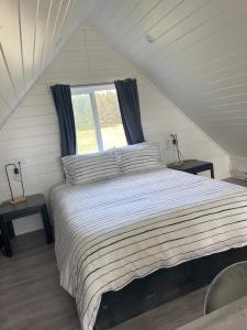 um quarto com uma cama grande e uma janela em Sunrise Loft - Beach front guest house em Sandspit