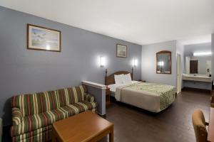 Habitación de hotel con cama y sofá en Scottish Inn & Suites, en Hankamer