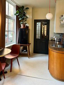 uma cozinha com uma porta preta e uma televisão num quarto em Pandje 118 - Binnenstad Kampen em Kampen
