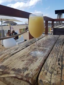 a glass of orange juice sitting on a wooden table at Ocean Roof in Santa Maria