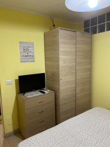 a bedroom with a bed and a dresser with a television at Monolocale PIRILÙ in Reggio Calabria