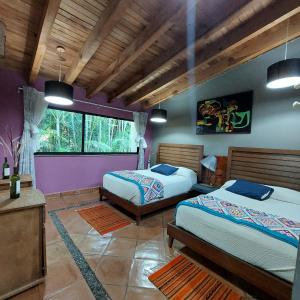 a bedroom with two beds and a large window at Casa Valle Horus in Valle de Bravo