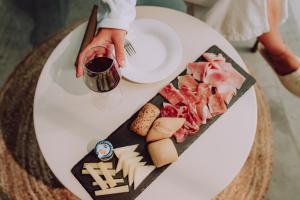 Aurora Boutique Hotel & Private SPA في سبوليتو: طاولة مع طبق من الطعام وكأس من النبيذ