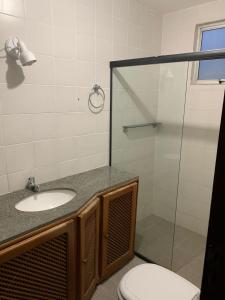 a bathroom with a toilet and a sink and a shower at APARTAMENTO PRAIA DO MORRO, 04 QUARTOS, ATE 10 PESSOAS. in Guarapari