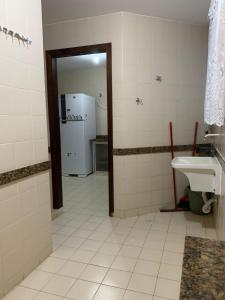 y baño con lavabo y nevera. en APARTAMENTO PRAIA DO MORRO, 04 QUARTOS, ATE 10 PESSOAS., en Guarapari