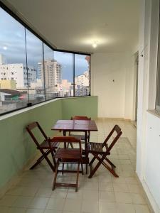 een tafel en stoelen op een balkon met uitzicht bij APARTAMENTO PRAIA DO MORRO, 04 QUARTOS, ATE 10 PESSOAS. in Guarapari