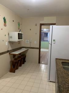 eine Küche mit einem weißen Kühlschrank und einer Spüle in der Unterkunft APARTAMENTO PRAIA DO MORRO, 04 QUARTOS, ATE 10 PESSOAS. in Guarapari