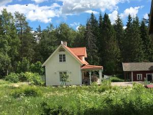 una pequeña casa blanca en medio de un campo en Vacation in Wonderful environment! - Uppsala, 