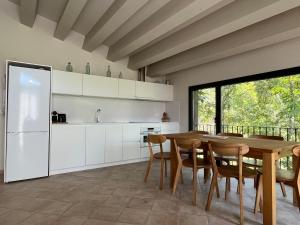 een keuken met een tafel en stoelen en een koelkast bij Casa de camp Les Tretes in Les Preses