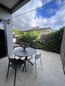 a patio with a table and chairs on a patio at Beach side Duplex in Punaauia