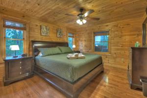 Schlafzimmer mit einem Bett und einem Deckenventilator in der Unterkunft ENJOY & have some FUN! Cabin with Game Room & Hot Tub in Blue Ridge