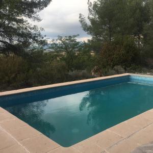 una piscina azul con árboles en el fondo en Vi l'Art Wine Lodge, en Piera