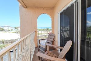 2 Stühle auf einem Balkon mit Meerblick in der Unterkunft Creston House 4C in St. Augustine