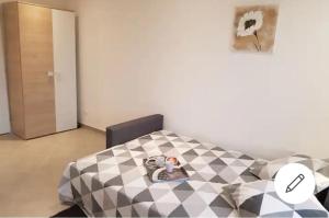a room with a bed with a black and white pattern at STUDIOS NEUFS ET AGRÉABLES in Bonneuil-sur-Marne