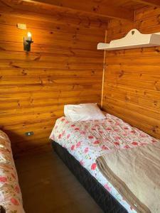 a bedroom with a bed in a wooden cabin at Algarrobo Beach House Casa de Playa in Algarrobo