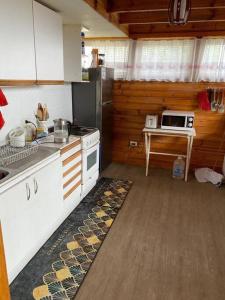 cocina con fogones y mesa con microondas en Algarrobo Beach House Casa de Playa, en Algarrobo