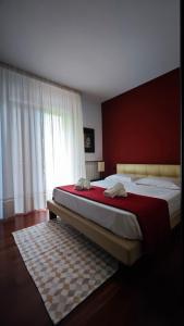 - une chambre avec 2 lits et un mur rouge dans l'établissement Villa Rossella, à Scafati