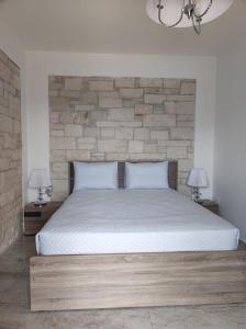 een bed in een slaapkamer met een bakstenen muur bij Ioanna Apartment 2 in Chania