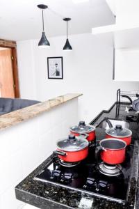 a kitchen with four pots on a stove top at Apartamento Econômico na Gilka Machado in Rio de Janeiro