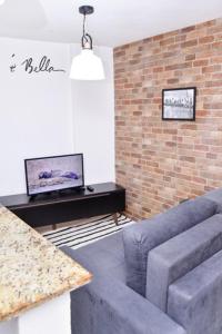 a living room with a couch and a tv at Apartamento Econômico na Gilka Machado in Rio de Janeiro