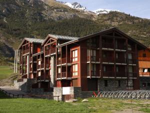 a large building with mountains in the background at Appartement Lanslevillard, 2 pièces, 4 personnes - FR-1-508-23 in Lanslevillard