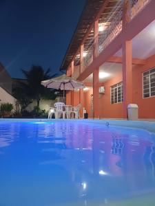 una piscina frente a una casa por la noche en A S Suites en Angra dos Reis