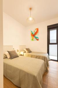 una camera con due letti e un lampadario a braccio di Cathedral Apartment Welcome wheelchairs 6 pax a Siviglia