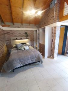 Un dormitorio con una cama en una habitación con techos de madera. en Cabaña Los ALAMOS, en Los Reartes