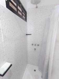 Un baño blanco con ducha y WC. en Cabaña Los ALAMOS, en Los Reartes
