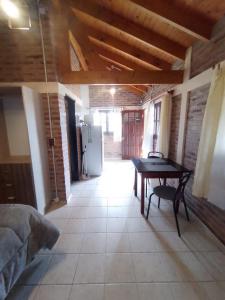una habitación con una mesa en el medio de una habitación en Cabaña Los ALAMOS, en Los Reartes