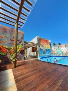 Una casa con una terraza con una pintura. en Chalé Palhano Beach en São Miguel dos Milagres