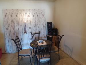 a dining room with a table and chairs and a curtain at R reasonable Air BNB. in Montego Bay