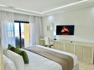 um quarto de hotel com uma cama e uma televisão na parede em Hacienda Samana Bay Residences em Santa Bárbara de Samaná