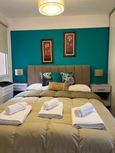 1 dormitorio con 1 cama grande y toallas. en Alvarado Apart en Bahía Blanca